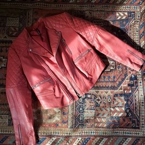 Here is a cool moto style leather jacket in a coral pink with silver zippers.